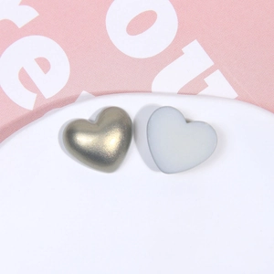 Vue macro d'accessoires DIY en forme de cœur en or champagne et gris translucide