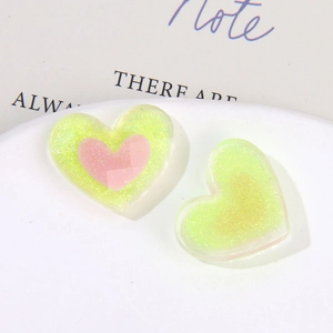 Vista macro di ciondoli in resina a forma di cuore con glitter e finitura bicolore