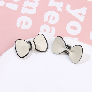 Detail of cream acetate bow jewelry accessories with contrasting black edges on a clip