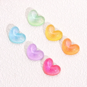 Vista macro di ciondoli a cuore in resina glitterata in sei tonalità pastello per il fai da te