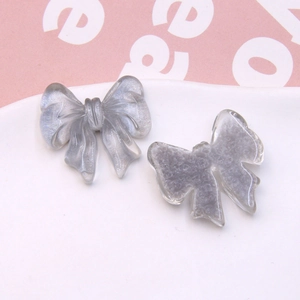 Detailed view of silver-gray bow resin charms with pearlescent matte texture for DIY