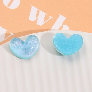 Dettaglio di ciondoli a cuore in resina blu glitterata per accessori capelli fai da te