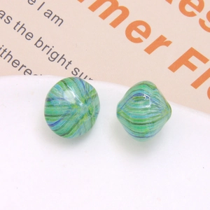 Macro shot of striped resin beads with green and blue swirl pattern for DIY jewelry
