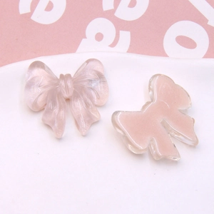 Close-up of pink translucent resin bow charms for DIY jewelry and hair accessories