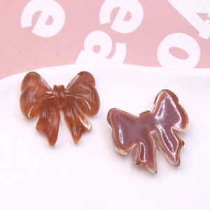 Detailed macro view of brown resin bow accessories for DIY jewelry making and crafts