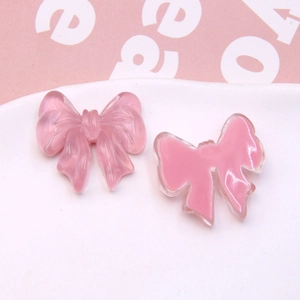 Macro view of semi-transparent pink resin bow accessories for DIY jewelry making