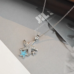 Détail d'un collier avec pendentif étoile de mer superposé en zircons et texture bleue