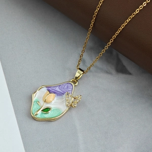 Dettaglio di collana dorata vintage con pendente smaltato a tulipano e farfalla di diamanti