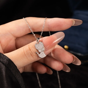 Nahaufnahme einer Halskette mit Katzenanhänger aus Silber und Zirkonia auf einer Hand