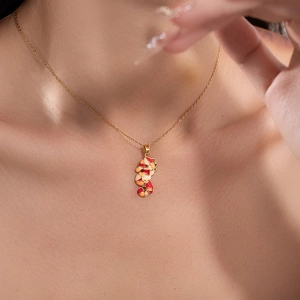 Détail du collier pendentif hippocampe avec émail coloré sur une chaîne dorée
