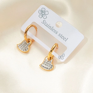 Detalle de pendientes de aro en acero dorado con colgantes de corazones de cristal