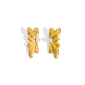 Macro detail of gold bow-shaped earrings with central pearl and textured wings