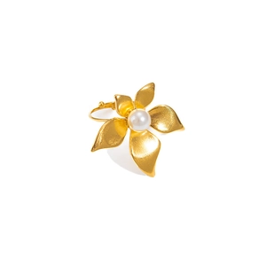 Macro shot of gold floral earrings with matte petals and a white center pearl detail