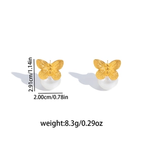 Detail view of gold bow pearl earrings with size measurements of 2.91 cm and 2.00 cm