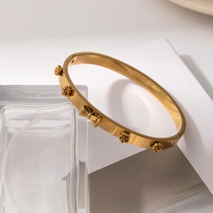 Elegant gold-plated stainless steel bangle featuring 3D rose and bow tie design charms