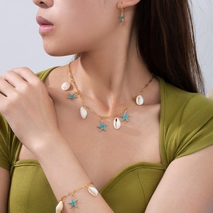 Dettaglio del set collana e bracciale con ciondoli a stella marina e conchiglia