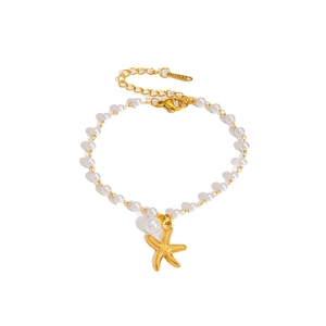 Dettaglio bracciale di perle bianche con ciondolo a stella marina e chiusura in acciaio