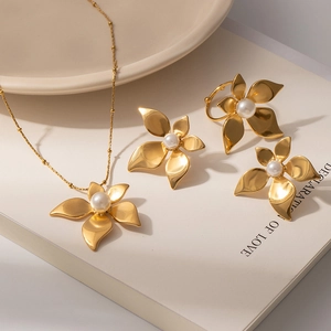 Macro view of gold flower jewelry set with white pearls on a decorative book