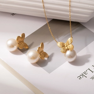 Luxury gold butterfly pearl necklace and earrings jewelry set on elegant background