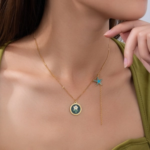 Collana oceano dorata con ciondolo a fiore, stella marina e nappa su una modella