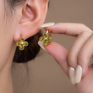 Eleganti orecchini a fiore dorati con zirconi verdi e design a quadrifoglio