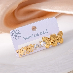 Macro shot of 3-pair stainless steel earring set with gold butterfly and zircon studs