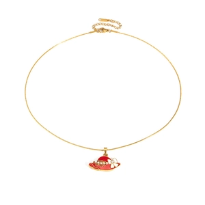 Detail of gold necklace featuring a red hat pendant with white bow and pearls