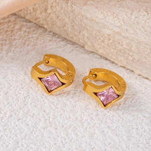 Detailed macro view of gold-plated square-cut pink zircon earrings on silk texture
