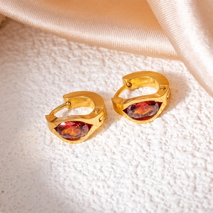 Detail of gold titanium hoop earrings featuring marquise-cut purple zircon and brushed finish