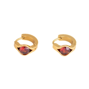 Detailed macro shot of gold-plated drop earrings featuring round red zircon stones