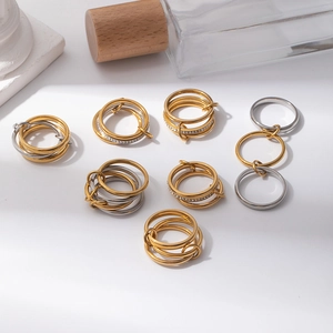 Dettaglio di anelli a fascia in acciaio inossidabile oro e argento con pavé di cristalli