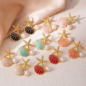 Gros plan détaillé de boucles d'oreilles étoile de mer émaillées colorées avec perles blanches