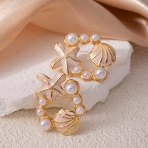 Vue détaillée des boucles d'oreilles étoile de mer et coquillage avec perles blanches