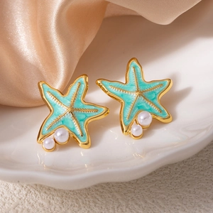 Gros plan détaillé des boucles d'oreilles étoile de mer avec émail bleu et perles