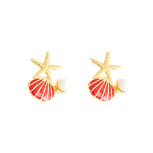 Macro detail of gold starfish earrings with red enamel shell and white pearls