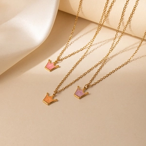 Detail van kleurrijke kroonhangers in roze, oranje en paars met gouden kettingen