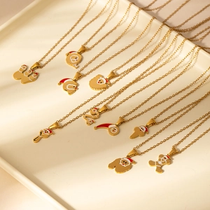 Détail de colliers pendentifs Père Noël en acier inoxydable doré sur un plateau