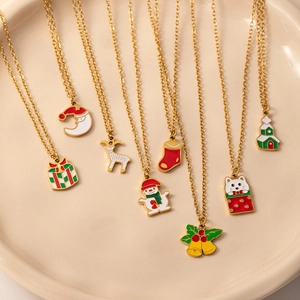 Collection de huit pendentifs de Noël en émail festif sur des colliers dorés dans un plateau