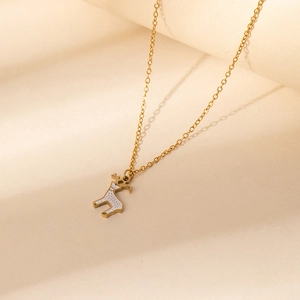 Détail d'un collier pendentif renne doré avec émail blanc et points marrons