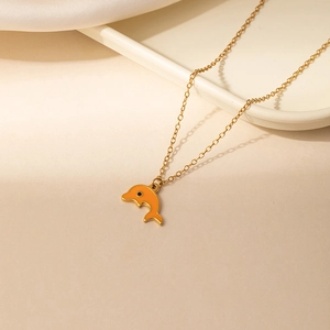 Gedetailleerde weergave van een oranje dolfijn hanger met gouden rand aan een gouden ketting
