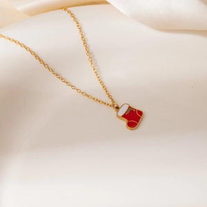 Close-up of a festive Christmas stocking pendant necklace with red and white oil drip finish