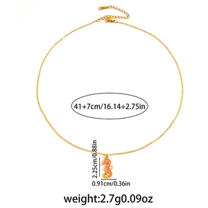 Gedetailleerd beeld van een gouden zeepaardje hanger met roze emaille en maatvoering