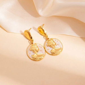 Detail of vintage gold coin earrings with pink enamel and queen portrait relief