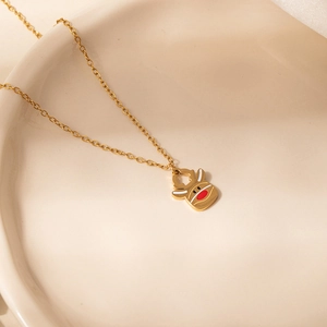 Vue détaillée du collier pendentif renne de Noël avec nez émaillé rouge sur chaîne dorée
