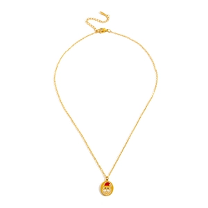 Vue macro d'un pendentif Père Noël doré avec détails en émail rouge sur fine chaîne