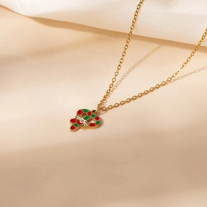 Close-up of golden Christmas candy cane necklace with red green enamel and bow detail