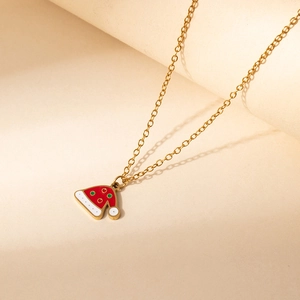 Close-up of golden Christmas hat pendant with red enamel and textured white details