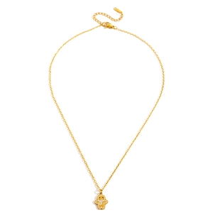 Close-up of gold gingerbread man pendant necklace with white enamel details for Christmas