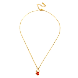 Detail of gold necklace with red Christmas glove pendant featuring a yellow snowflake