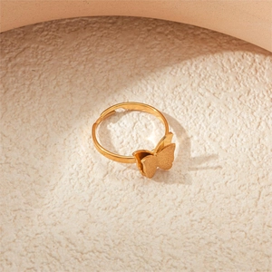 Detail of golden double-layer butterfly ring featuring brushed texture and polished finish